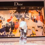 Woman Standing in Front of Dior Store Front