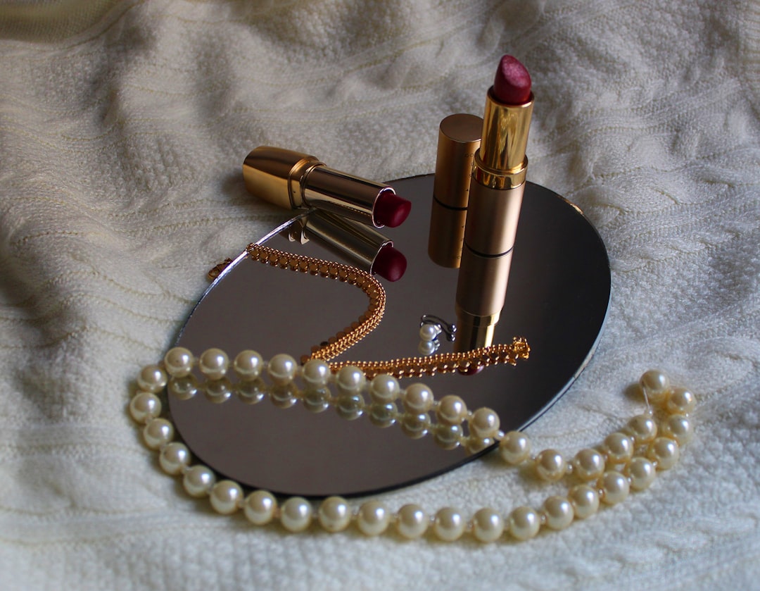 Accessories by Makeup Brands white pearl necklace beside pink lipstick