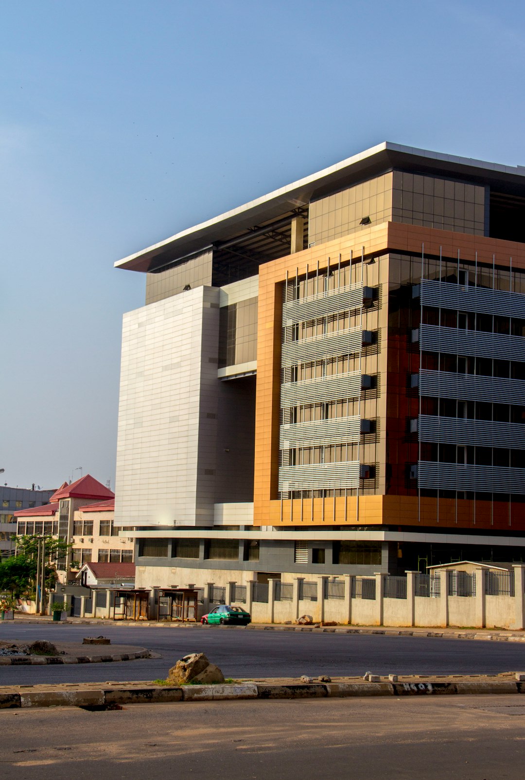 Abuja, Nigeria by Makeup Brands brown and white concrete building under blue sky during daytime